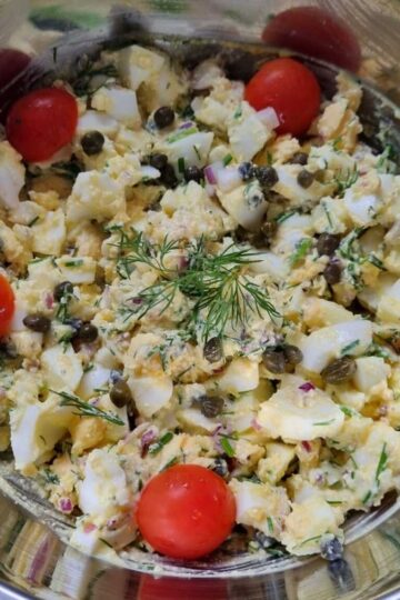 Picture of the final egg salad dish garnished with cherry tomatoes and chopped dill.