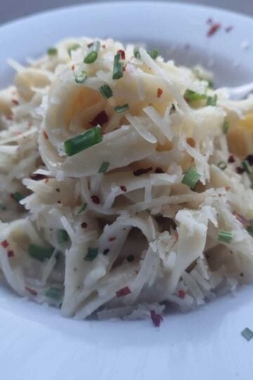 Bowl of fettucine pasta in cottage cheese alfredo sauce with fork,