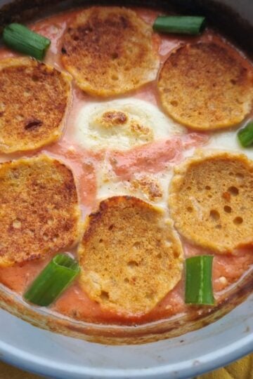 Bowl of cottage cheese pizza garnished with six pieces of turkey pepperoni, mozarella cheese and green onion pieces.