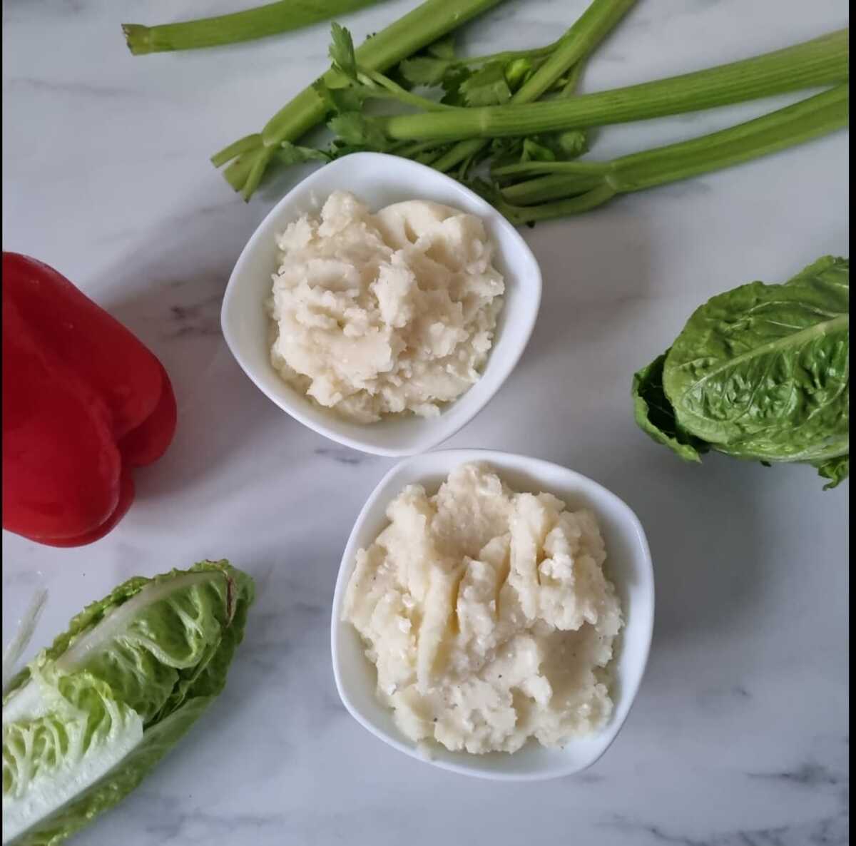 Two bowls filled with creamy cottage cheese mashed potatoes.
