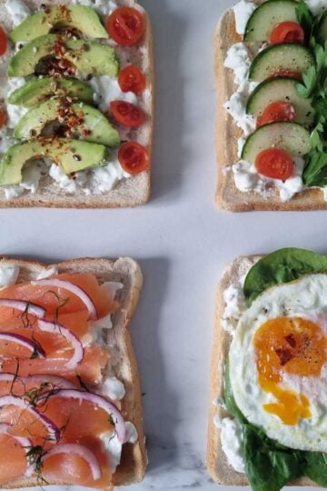 Four different cottage cheese toasts o ne with avocado and tomatoes, one with cucomber and cherry tomatoes, one with smoked salmon, and one with spinach and egg.