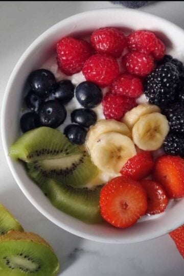 A bowl containing cottage cheese and fruits.