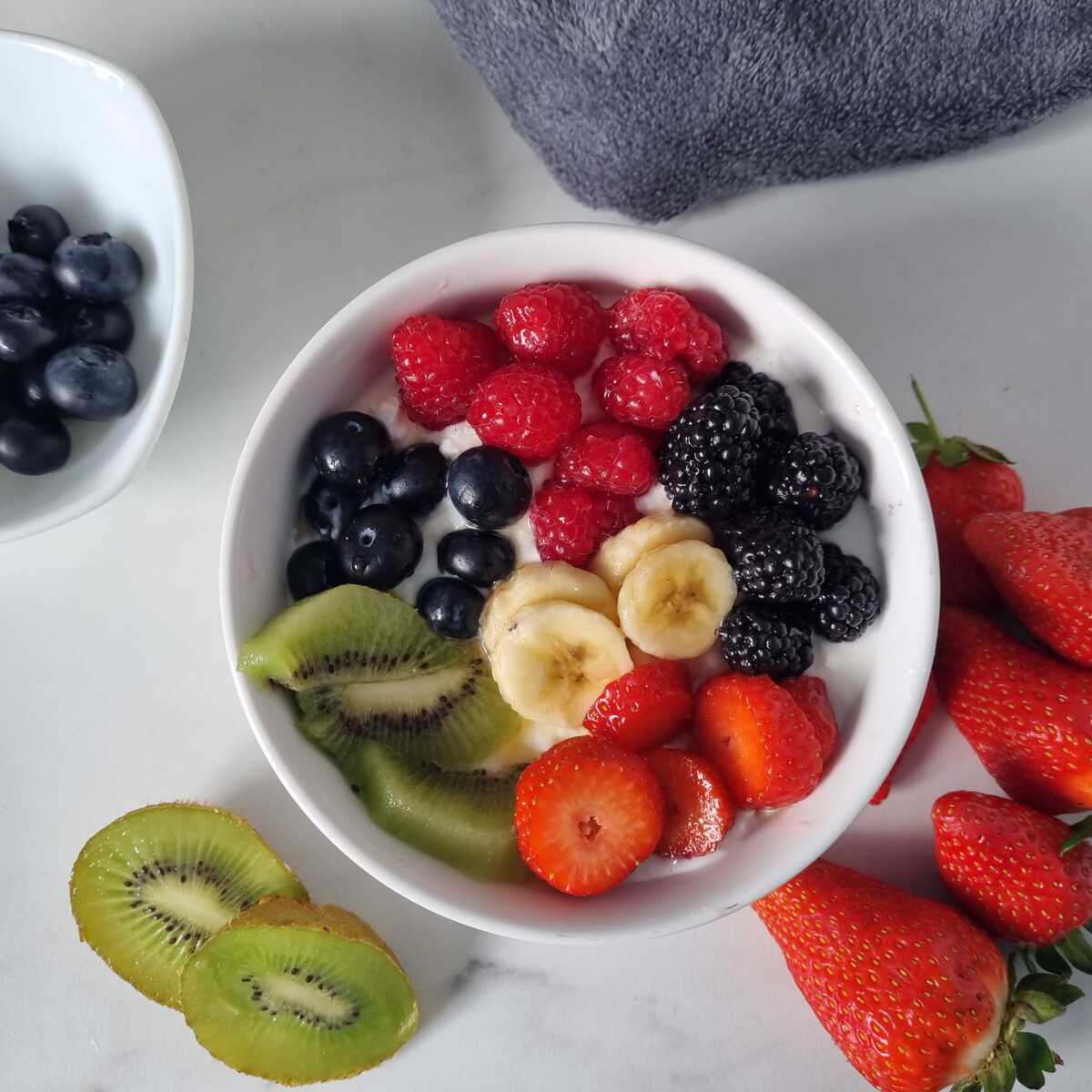 Bowl of cottage cheese topped with assorted fresh fruits.