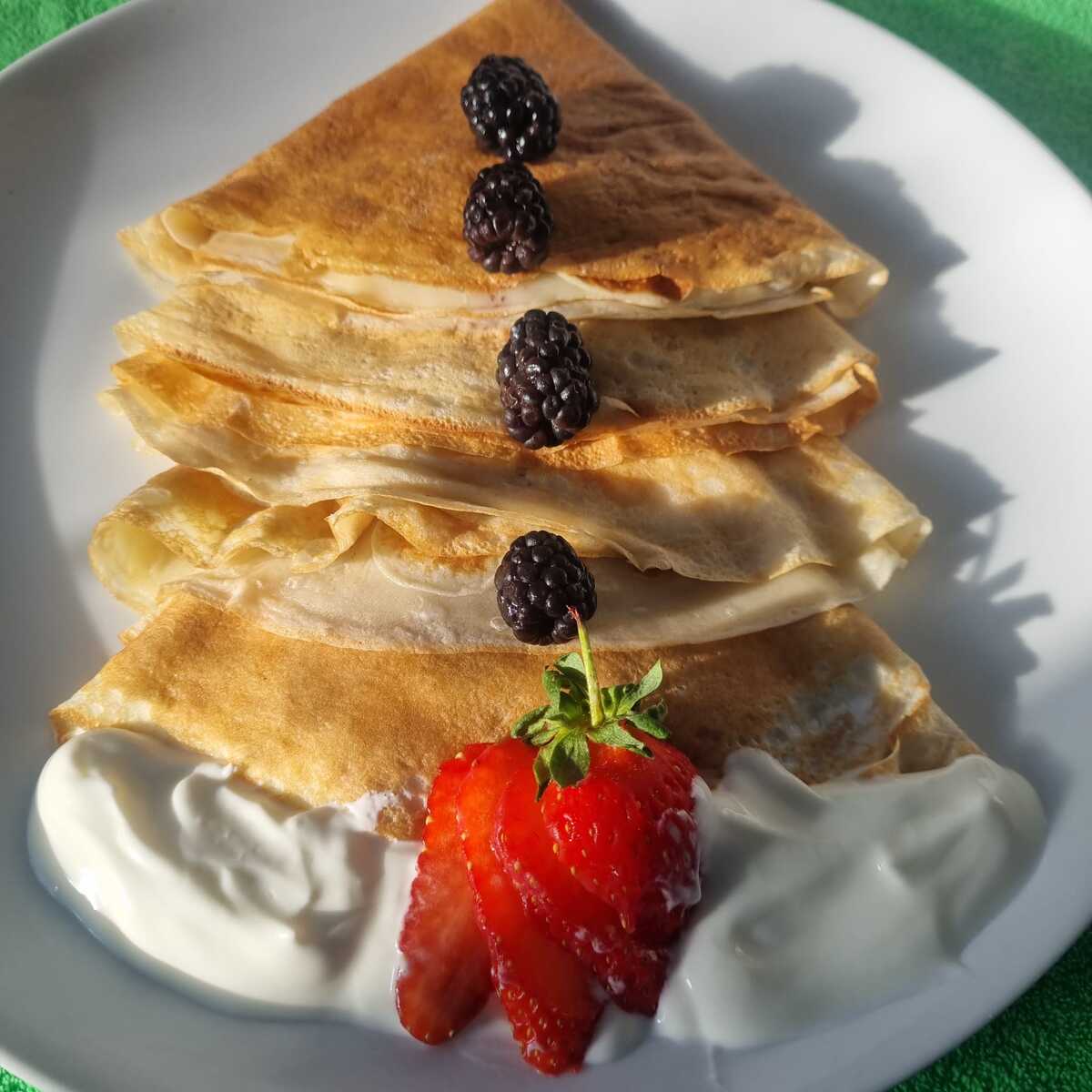Ingredients for high-protein cottage cheese crepes on a counter,  cottage cheese, eggs, milk, flour, sweetener, vanilla, and a pinch of salt ready to blend.